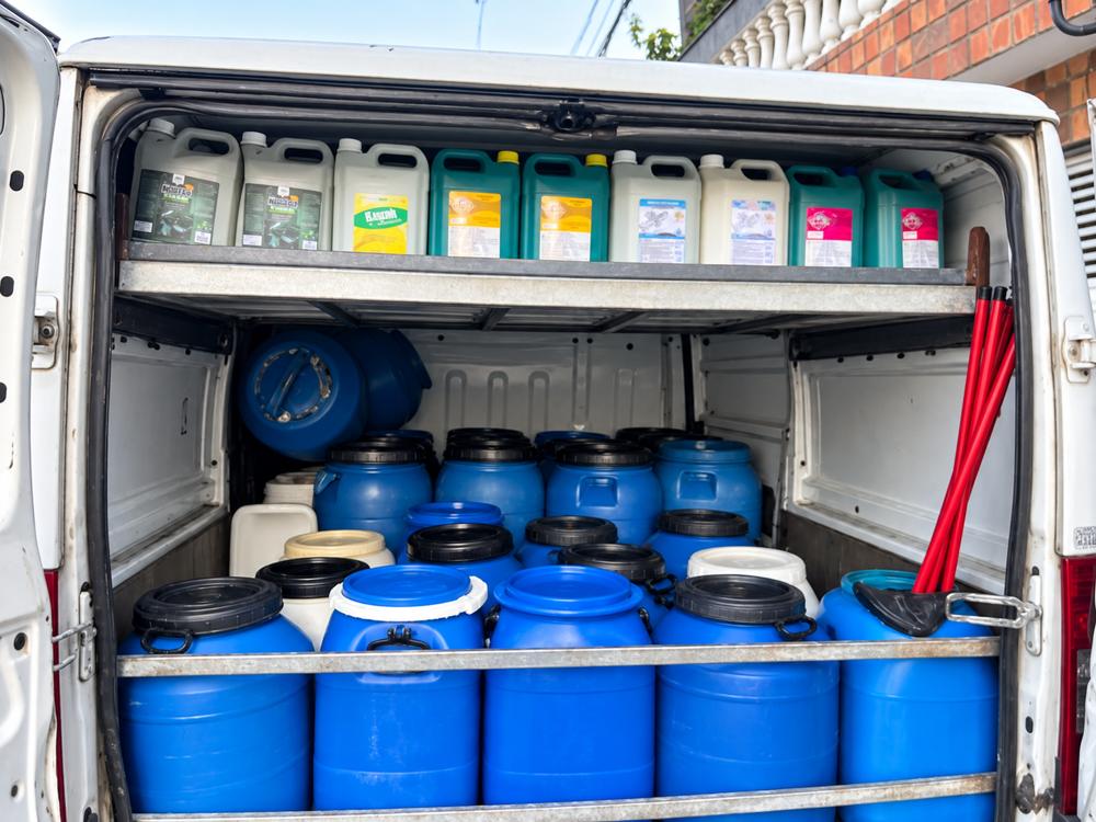 Interior de van com recipientes azuis para armazenar óleo e produtos de limpeza